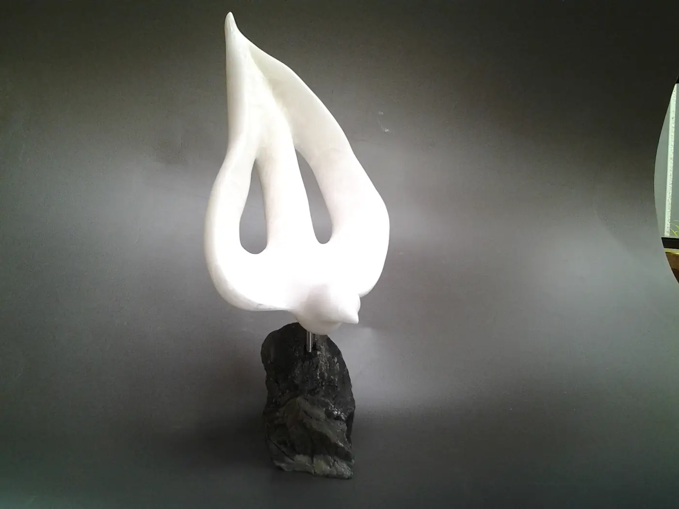 Peace, a white stone dove sculpture on a dark base